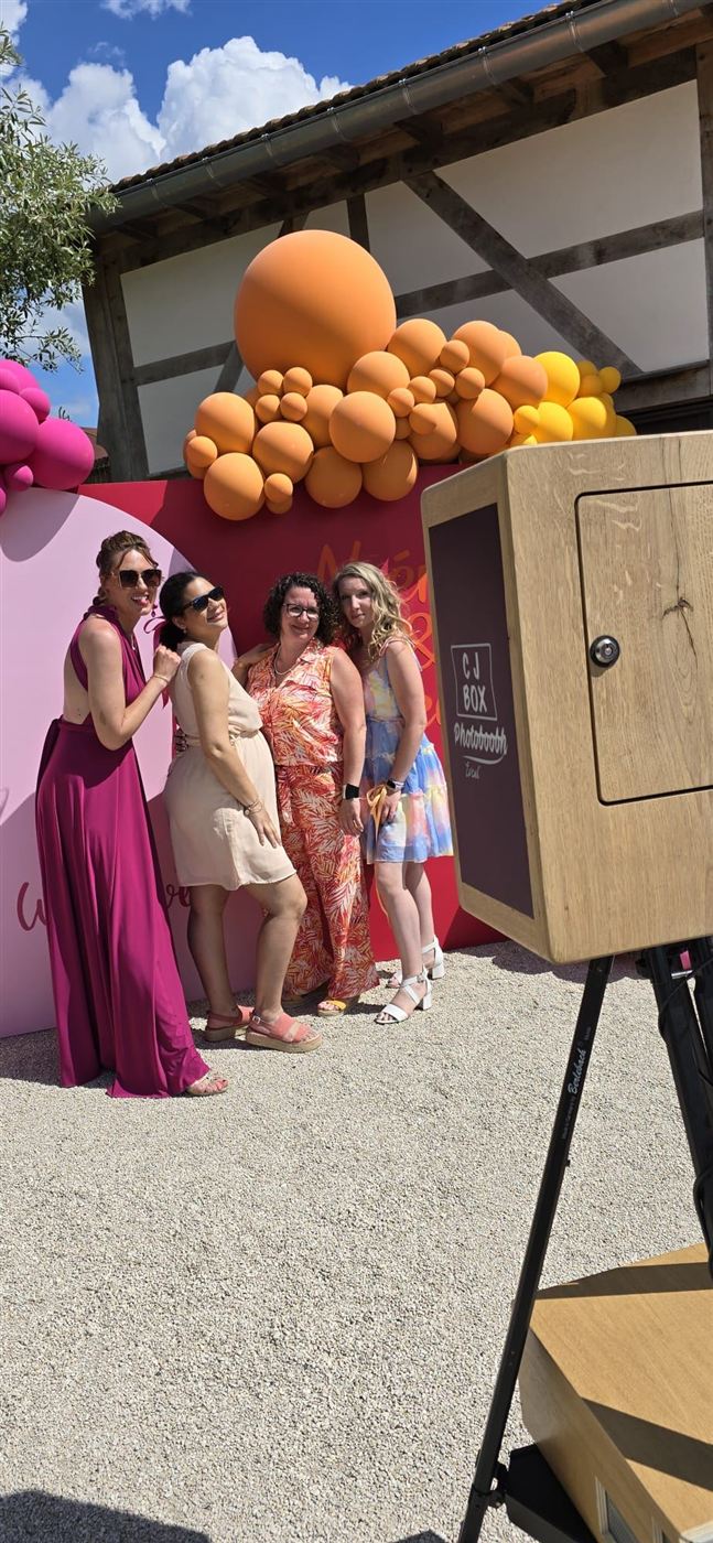 Invités posant devant la borne photo en bois CJ BOX