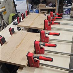 Collage des panneaux en bois massif serrés au serre-joint dans l'atelier GEN3D